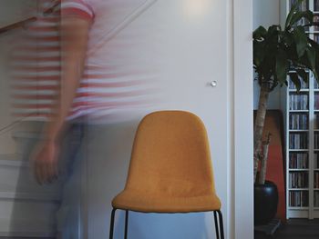 Low section of woman sitting on chair at home