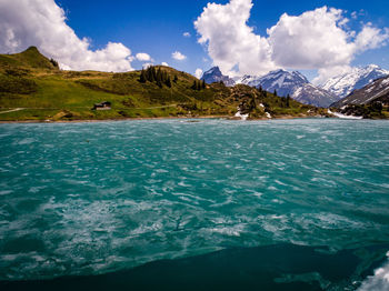 Scenic view of sea by mountains against sky