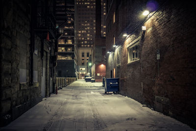 Street amidst illuminated buildings in city at night