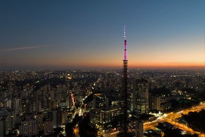 Aerial view of illuminated city buildings against sky