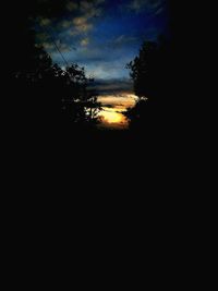 Silhouette trees against sky at sunset