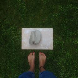 Low section of woman standing on green grass