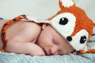 Close-up of baby sleeping on bed at home