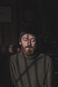 Portrait of young man standing against wall