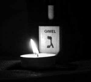 Close-up of lit candle in darkroom