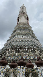 Pagoda low angle views at wat arun, under a dramatic cloudy sky