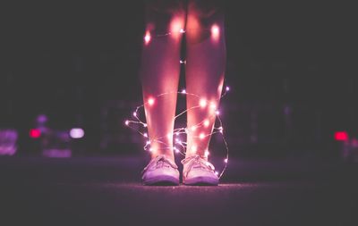 Low section of man standing at night