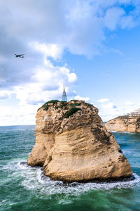 Stack rock in sea against sky