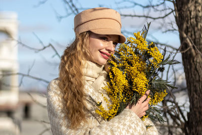 A  woman with a yellow acacia flowers. the concept of the spring - march 8, easter, women's day