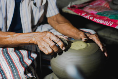 Midsection of man making pottery