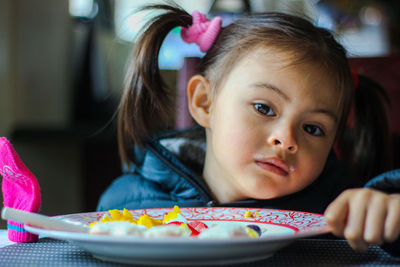 Portrait of cute baby girl on table