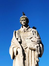 Low angle view of statue against blue sky