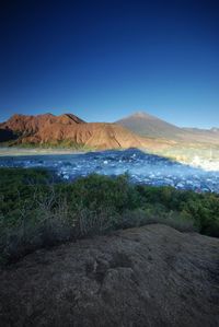 Scenic view of land against clear blue sky