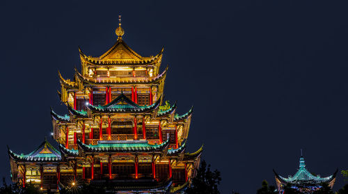 Low angle view of illuminated building against sky at night