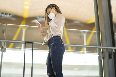 Tourist the airport with the mask using his smartphone