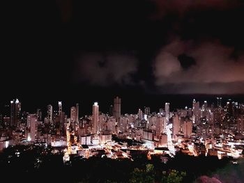 Illuminated cityscape against sky at night