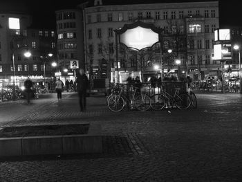 People on illuminated city street at night