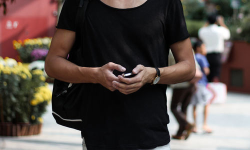 Midsection of man using mobile phone