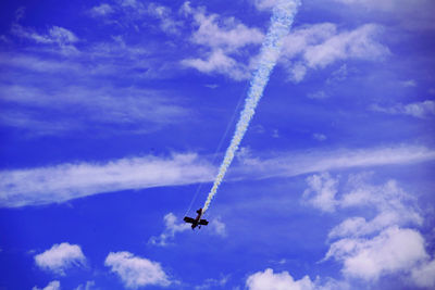 Low angle view of airplane flying against blue sky