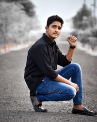 Portrait of young man sitting on land