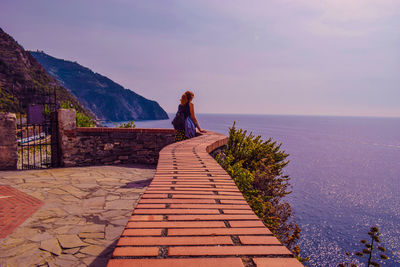 Woman standing by sea against clear sky