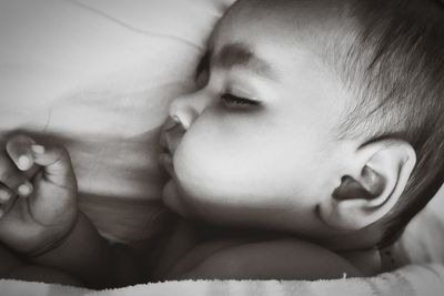 Close-up portrait of cute baby sleeping on bed