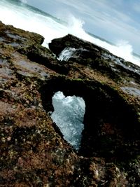 Close-up of rock in sea against sky