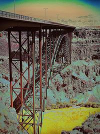 Arch bridge over river against sky