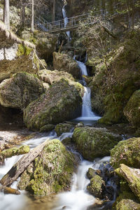 View of stream flowing through rocks