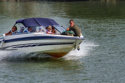 People in boat sailing on river