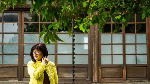 Portrait of woman standing against plants