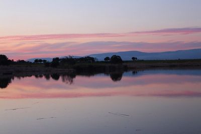 Scenic view of lake against sky at sunset