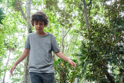 Portrait of smiling boy standing against trees