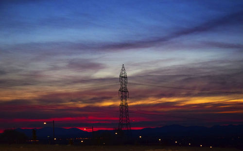 Silhouette electricity pylon against sky during sunset