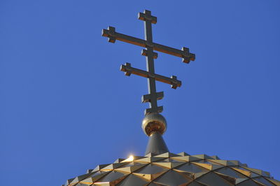 Low angle view of cross against clear blue sky