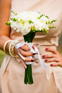 Midsection of woman holding flower bouquet