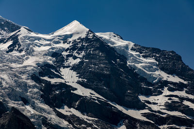 Scenic view of snowcapped mountains against clear sky
