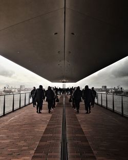 People walking on bridge against sky