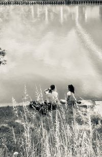 People sitting on field by land