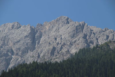 Low angle view of rocky mountains against clear sky