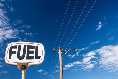 Low angle view of road sign against blue sky