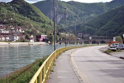 Road by river and buildings in city