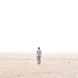 Rear view of woman standing on beach