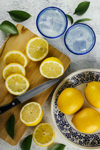 Freshly cut lemons with glasses of lemon juice at an outdoor picnic