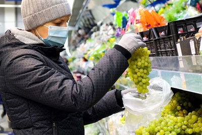 Side view of man holding fruits at market