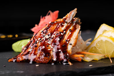 Close-up of meat on barbecue grill against black background