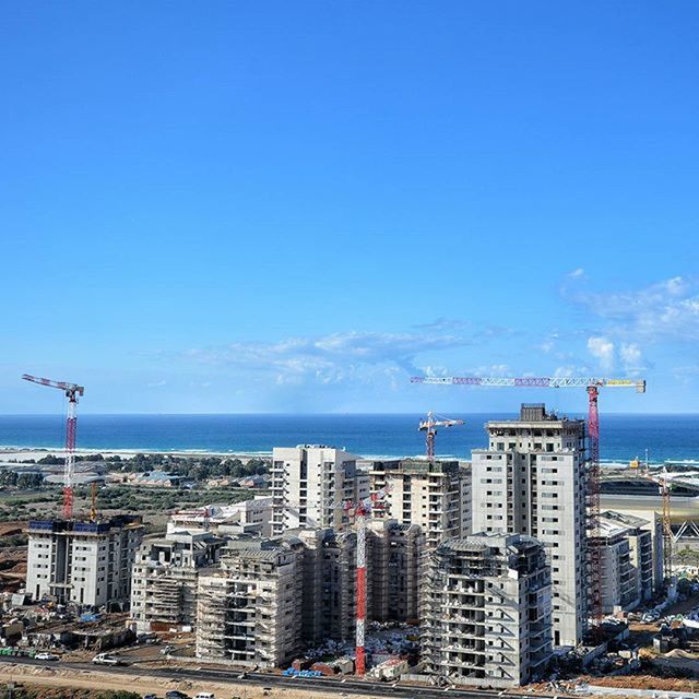 building exterior, architecture, built structure, city, sea, blue, cityscape, water, sky, copy space, skyscraper, clear sky, tower, horizon over water, day, transportation, office building, modern, travel, capital cities