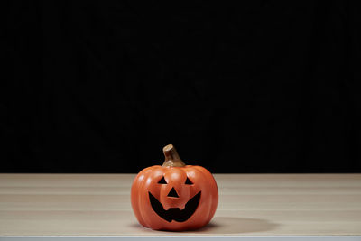 Close-up of pumpkin on table against black background