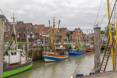 Boats moored at harbor in city