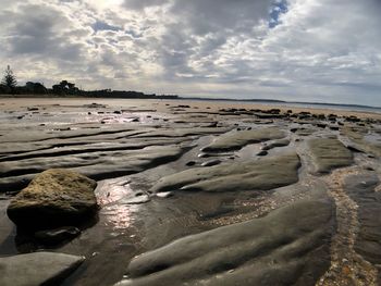 Rocks on beach against sky